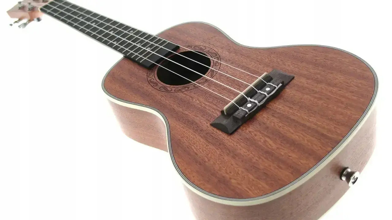 Brązowe ukulele z białym bindingiem, idealne do nauki gry na ukulele.