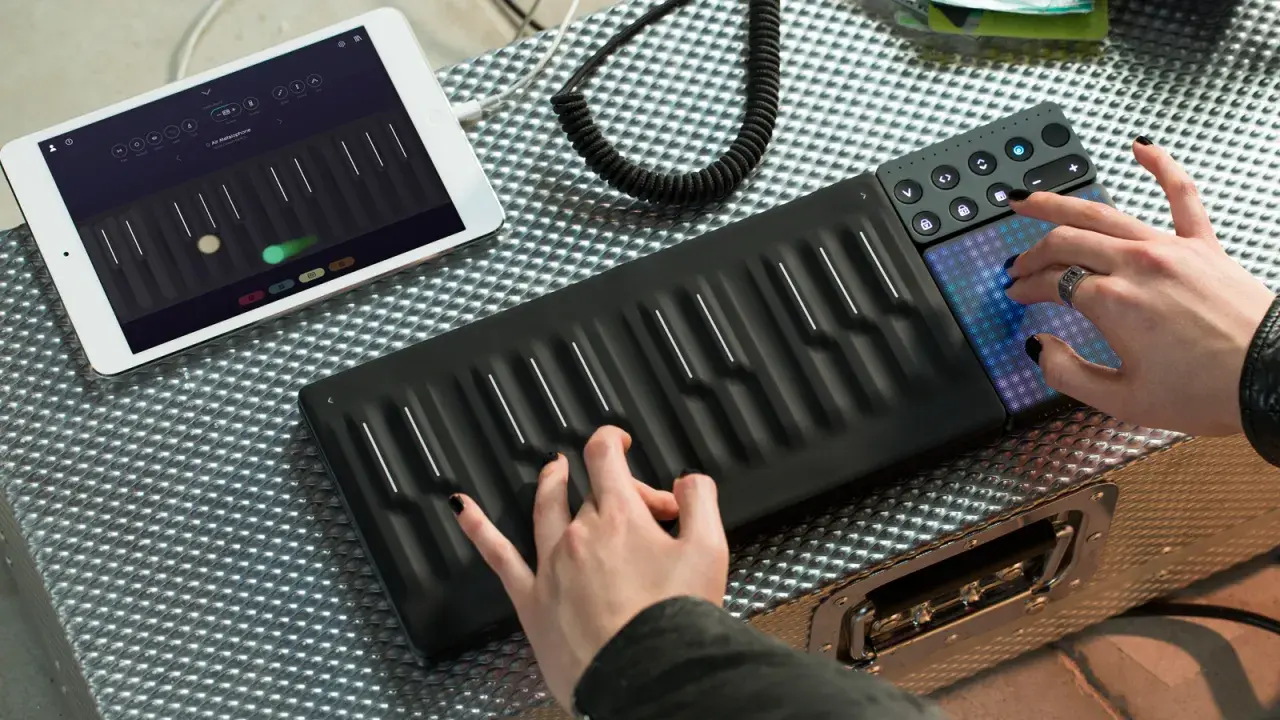 Tworzenie muzyki instrumentalnej elektronicznej na nowoczesnym kontrolerze. Ręce grające na klawiszach i dotykowe pady.