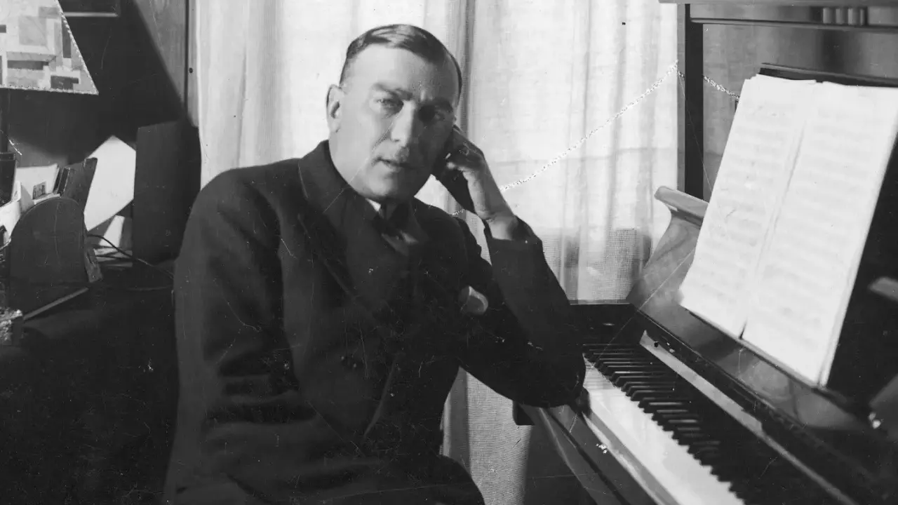 Karol Szymanowski, zamyślony przy fortepianie, z nutami na pulpicie.