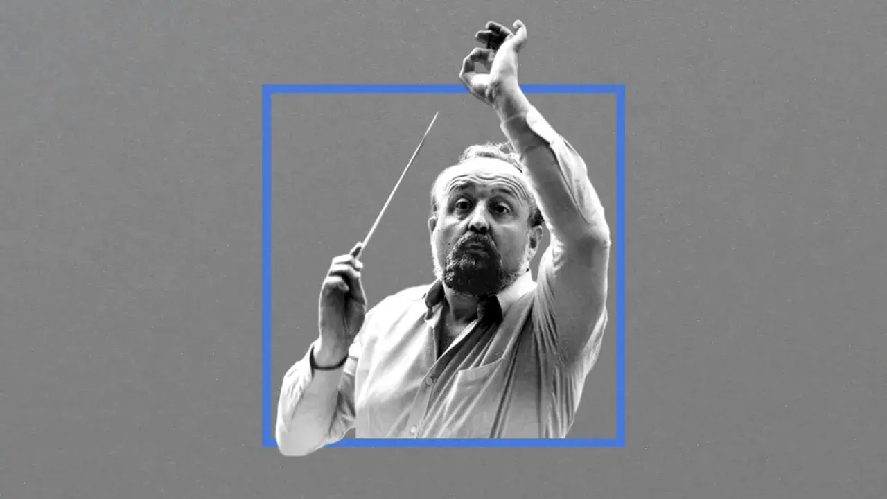 Krzysztof Penderecki, dyrygent z batutą w dłoni, w skupieniu prowadzi orkiestrę.
