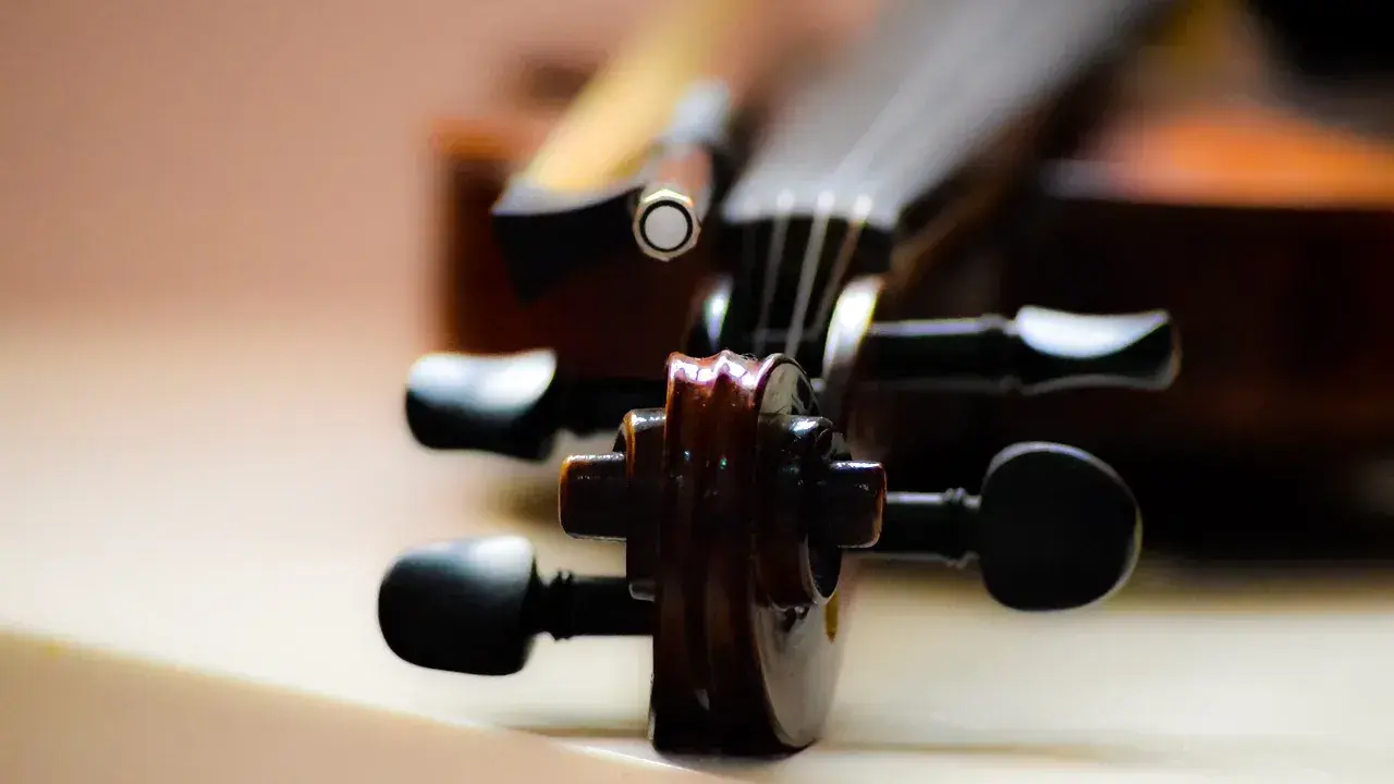 Główka skrzypiec, instrumentu podobnego do oratorium, z widocznymi kluczami i fragmentem smyczka.