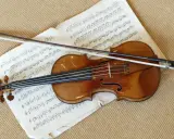 Stradivarius instrument leży na nutach, gotowy do gry.
