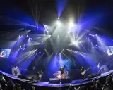 Koncert metalowy z wokalistą na scenie, gitarzystami i perkusistą. Efekty świetlne tworzą niesamowitą atmosferę. To najlepsze wykonanie - metal!