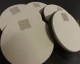 Kilka okrągłych, beżowych padów perkusyjnych z logo "DRUM SCHOOL" leży na czarnym tle.