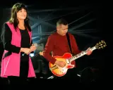 Kobieta z mikrofonem i mężczyzna grający na gitarze, polski blues wykonawcy na scenie.