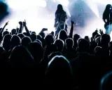 Tłum szaleje na koncercie, ręce w górze, światła sceny tworzą atmosferę legendy historii rocka.