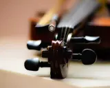 Główka skrzypiec, instrumentu podobnego do oratorium, z widocznymi kluczami i fragmentem smyczka.