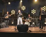 Zespół muzyczny na scenie: wokalistka, gitarzysta, klawiszowiec, saksofonista, basista i perkusista.