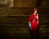Artystka w czerwonej sukni i chuście na głowie śpiewa fragment oratorium "Mesjasz" Georga Friedricha Händla.