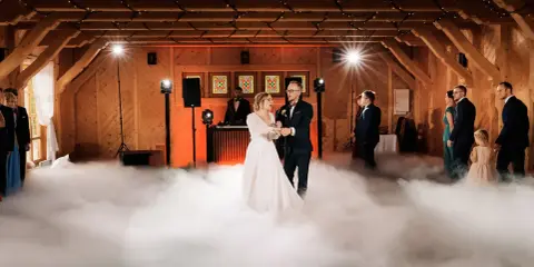 Para młoda tańczy w chmurach dymu scenicznego.