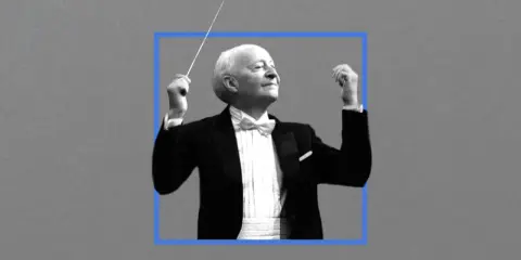 Witold Lutosławski, kompozytor, dyryguje orkiestrą w eleganckim fraku.
