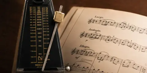 Metronom obok nut, gdzie widnieje tempo allegretto.