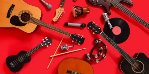 Instrumenty muzyczne, w tym gitary, mikrofony i bębenek, gotowe do zagrania czeskiej muzyki.