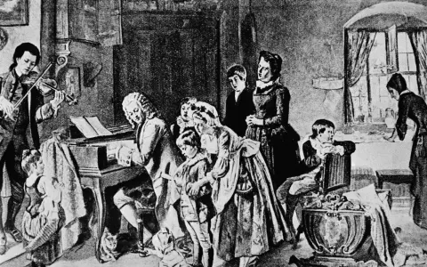 Johann Sebastian Bach z dziećmi w muzycznym domu. Syn gra na skrzypcach, ojciec przy klawikordzie, a reszta rodziny słucha.