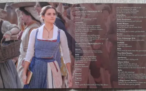 Piękna i Bestia muzyka: Belle w swojej wiosce, otoczona ludźmi i listą piosenek z filmu.