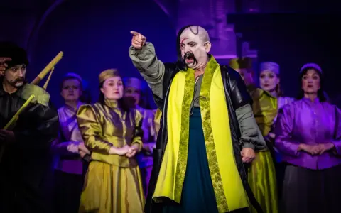 Aktorzy w barwnych strojach na scenie, przypominający postacie z operetki Moniuszki.
