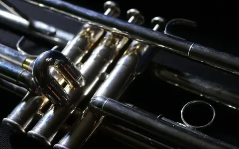 Błyszcząca, metalowa trąbka instrument, z widocznymi zaworami i rurkami, gotowa do wydobycia pięknych dźwięków.