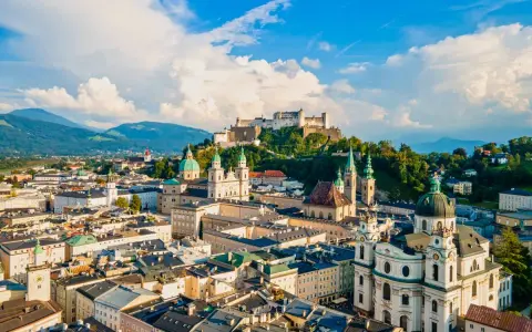 Widok na miasto z górami w tle, w tym Hohensalzburg. To ojczyzna Mozarta, Salzburga, z pięknymi kościołami i zabytkową architekturą.