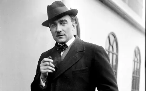 Elegancki mężczyzna w kapeluszu i muszce, palący papierosa. Może to Karol Szymanowski, który marzy o swoich dzieciach.