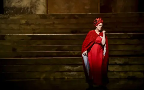 Artystka w czerwonej sukni i chuście na głowie śpiewa fragment oratorium "Mesjasz" Georga Friedricha Händla.