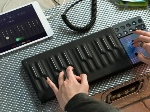 Tworzenie muzyki instrumentalnej elektronicznej na nowoczesnym kontrolerze. Ręce grające na klawiszach i dotykowe pady.