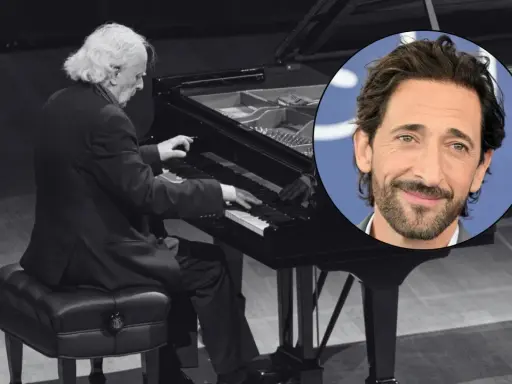 Adrien Brody, twórca muzyki do pianisty, w kadrze z wirtuozem przy fortepianie.