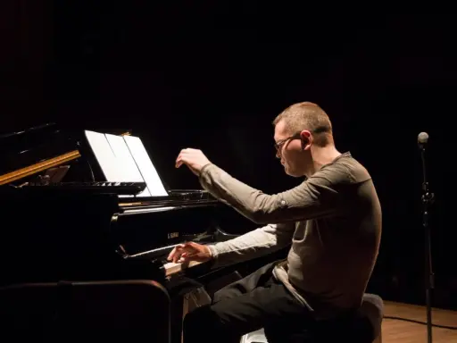 Znany polski kompozytor i pianista jazzowy, w skupieniu gra na fortepianie podczas koncertu.
