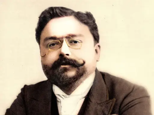 Portret kompozytora Isaaca Albéniza w okularach i z wąsami.