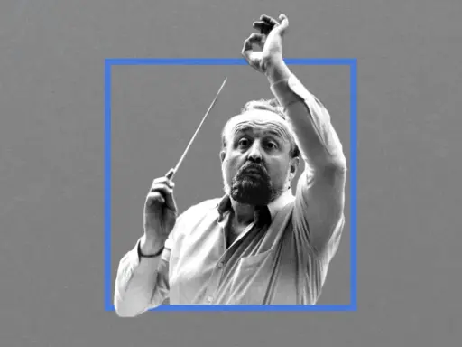 Krzysztof Penderecki, dyrygent z batutą w dłoni, w skupieniu prowadzi orkiestrę.
