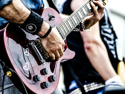 Muzyk gra na gitarze, przygotowując się do wykonania coverów piosenek.