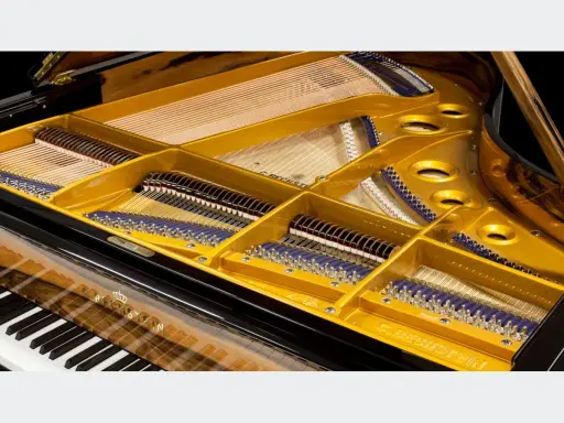 Wnętrze fortepianu z widocznymi strunami, młoteczkami i złotą ramą. Ten klawesyn instrument to dzieło sztuki.