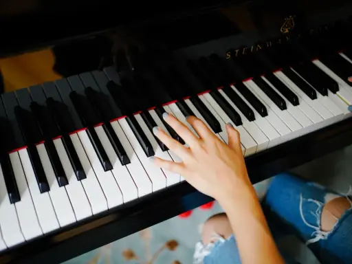 Dłoń grająca piosenkę na fortepianie Steinway.