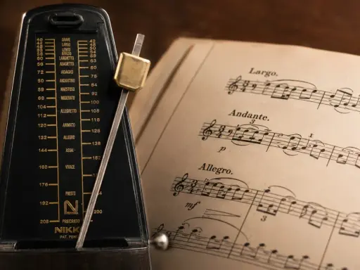 Metronom obok nut, gdzie widnieje tempo allegretto.
