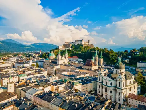Widok na miasto z górami w tle, w tym Hohensalzburg. To ojczyzna Mozarta, Salzburga, z pięknymi kościołami i zabytkową architekturą.