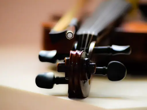 Główka skrzypiec, instrumentu podobnego do oratorium, z widocznymi kluczami i fragmentem smyczka.
