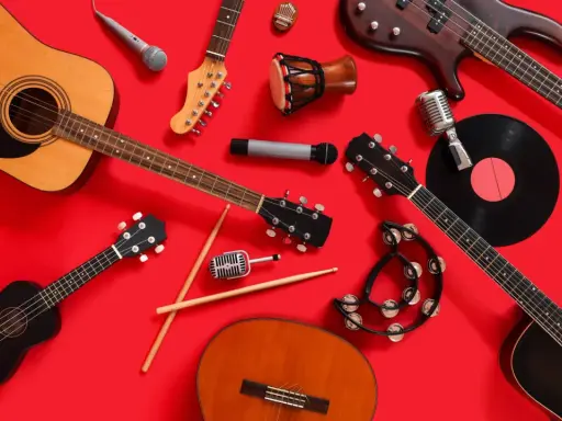 Instrumenty muzyczne, w tym gitary, mikrofony i bębenek, gotowe do zagrania czeskiej muzyki.