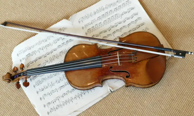 Stradivarius instrument leży na nutach, gotowy do gry.