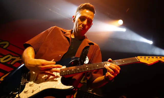 Cory Wong w akcie tworzenia muzyki na scenie, skupiony na grze na gitarze elektrycznej.