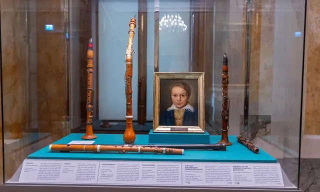 Portret młodego Beethovena i instrumenty muzyczne, które mogły być związane z miejscem urodzenia Ludwika van Beethovena.