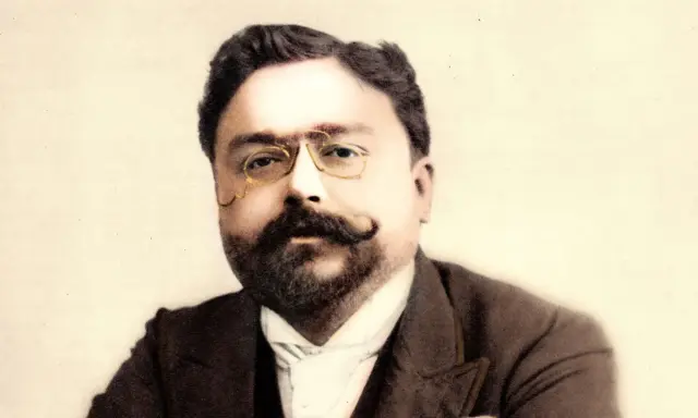 Portret kompozytora Isaaca Albéniza w okularach i z wąsami.