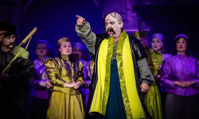 Aktorzy w barwnych strojach na scenie, przypominający postacie z operetki Moniuszki.
