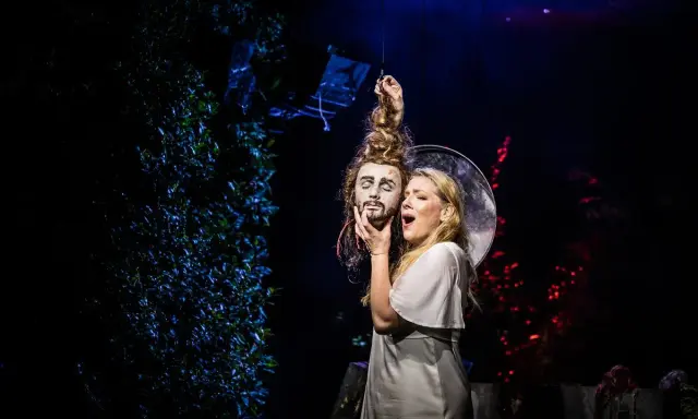 Salome, w białej sukni, trzyma odciętą głowę Jokanaana. Scena z opery Richarda Straussa, która jest jednym z jego najważniejszych utworów.