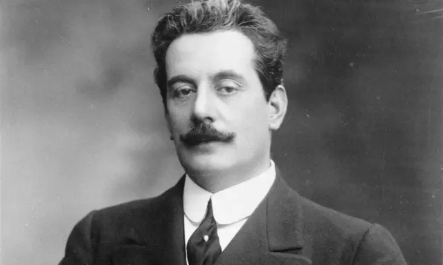 Portret Giacomo Pucciniego, kompozytora operowego, z charakterystycznymi wąsami i w eleganckim garniturze.