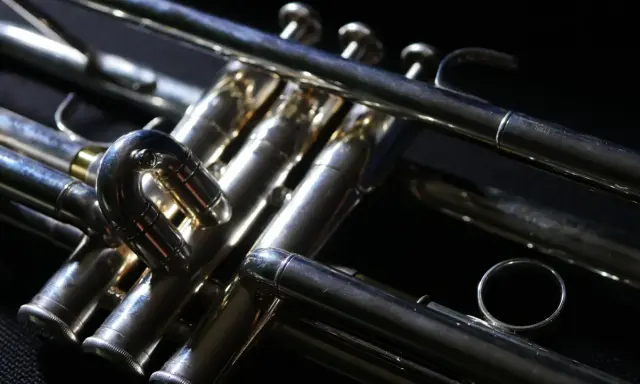 Błyszcząca, metalowa trąbka instrument, z widocznymi zaworami i rurkami, gotowa do wydobycia pięknych dźwięków.