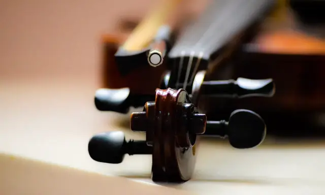 Główka skrzypiec, instrumentu podobnego do oratorium, z widocznymi kluczami i fragmentem smyczka.