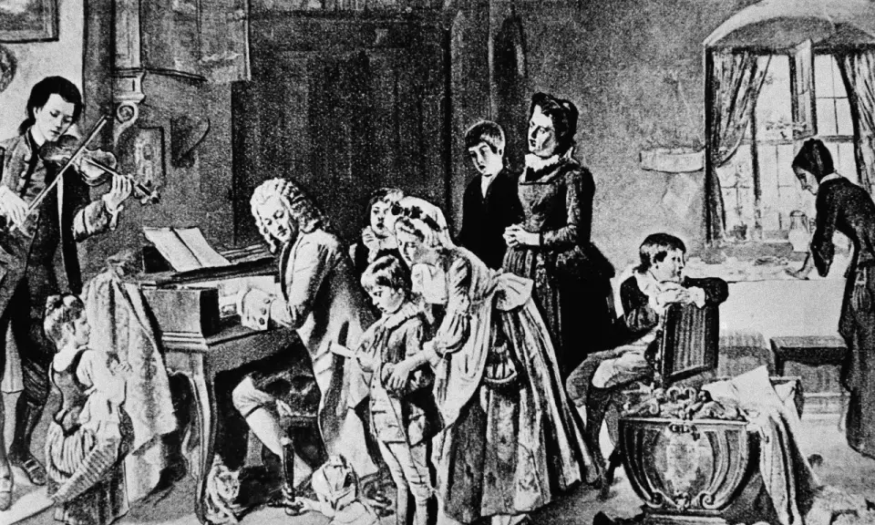 Johann Sebastian Bach z dziećmi w muzycznym domu. Syn gra na skrzypcach, ojciec przy klawikordzie, a reszta rodziny słucha.