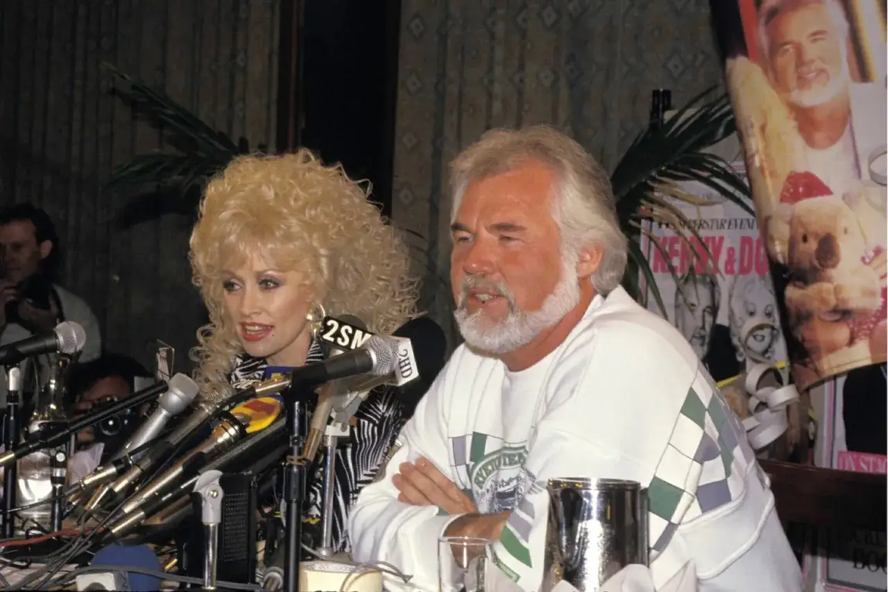Kenny Rogers i Dolly Parton przy mikrofonach. Na plakacie w tle widać okładkę płyty z ich wspólnymi utworami.