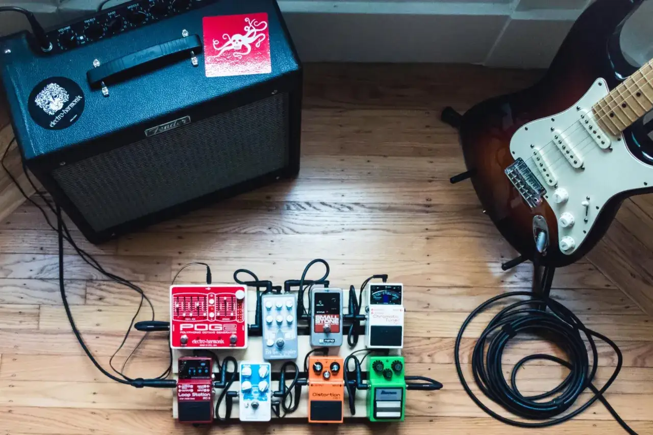 Zestaw do nauki, jak grać na gitarze elektrycznej: wzmacniacz, gitara, pedały efektów i okablowanie.
