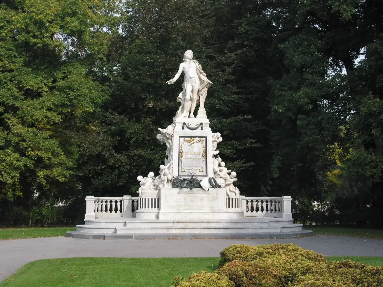 Pomnik Mozarta, wspaniały grób Mozarta, otoczony zielenią i rzeźbami puttów.