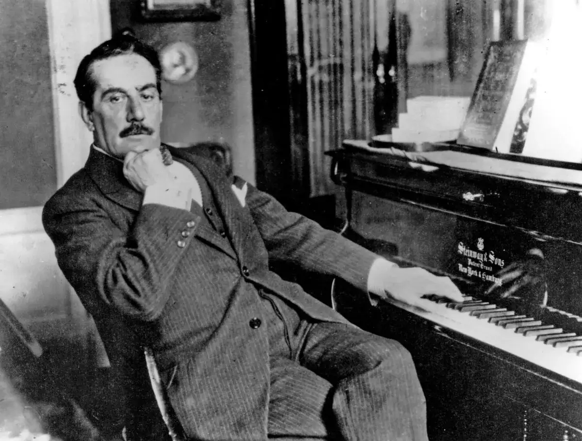 Giacomo Puccini, imię słynnego kompozytora, siedzi przy fortepianie Steinway, zamyślony.